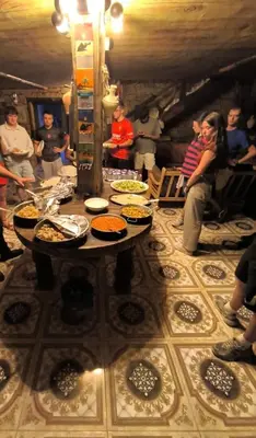 a group of people standing around a table with food on it at Dana Nabil Ecu Camp House - Main Gate Dana nature reserve in Dana