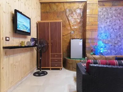 a living room with a television and a refrigerator at Yaso Roof & Apartments in Amman