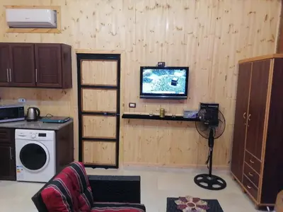 a living room with a tv and a washing machine at Yaso Roof & Apartments in Amman