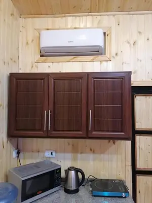 a kitchen with wooden cabinets and a microwave at Yaso Roof & Apartments in Amman
