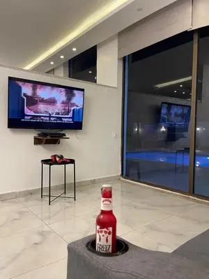 a bottle of drink sitting on a table in a room at Aroma Chalet in Sowayma