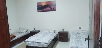 a room with two beds and a picture on the wall at شقه فندقيه.Apartment,Petra in Wadi Musa