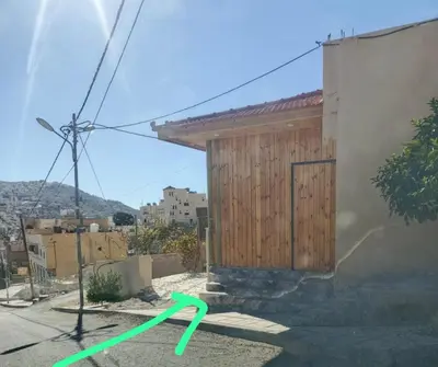 a green arrow on the side of a building at شقه فندقيه.Apartment,Petra in Wadi Musa