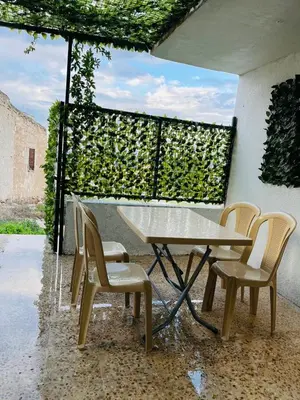 a table and two chairs and a table and a window at شقة سيلا in Irbid