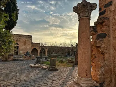 a stone column in a courtyard with a building at شقة سيلا in Irbid