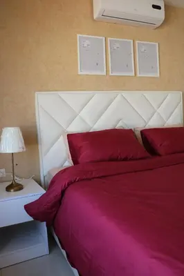 a bedroom with a large bed with red pillows at Ritala Royal Residence in Amman