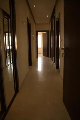 an empty hallway of a building with doors and floors at Ritala Royal Residence in Amman