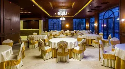 a banquet hall with white tables and yellow chairs at Ritala Royal Residence in Amman