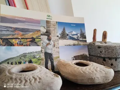 a man standing next to two donuts on a table at Beit Philodemus in Um Qeis