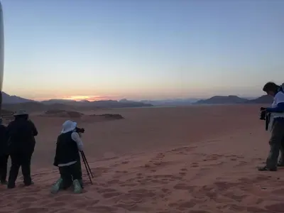 a group of people taking pictures of the desert at The calm nature of Wadi Rum in Wadi Rum