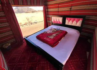 a bed in a room with a window at The calm nature of Wadi Rum in Wadi Rum