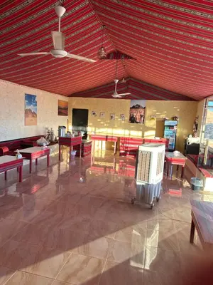 a large room with tables and benches and a red ceiling at Rum Luxury Camp in Wadi Rum