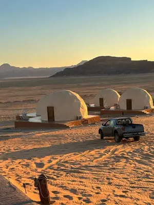 a car parked in front of three tents in the desert at Rum Luxury Camp in Wadi Rum