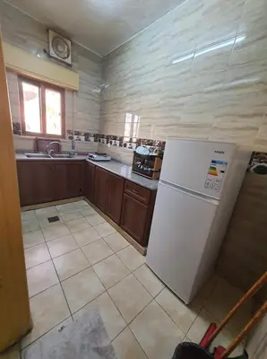 a kitchen with a white refrigerator in a room at العاصم للشقق الفندقية ALASEM HOTEL APARTMENTS in Aqaba