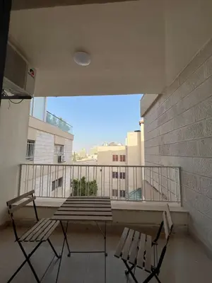 a balcony with two chairs and a table on a building at Bedouin Break Condo - In the Heart of Amman in Amman