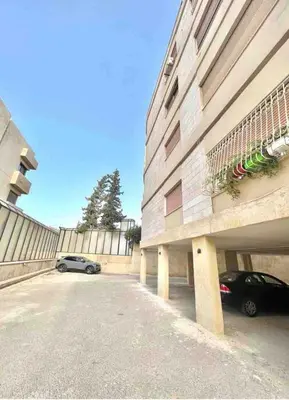 a car parked in a parking lot next to a building at Bedouin Break Condo - In the Heart of Amman in Amman