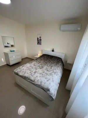 a bedroom with a large bed and two night stands at Bedouin Break Condo - In the Heart of Amman in Amman