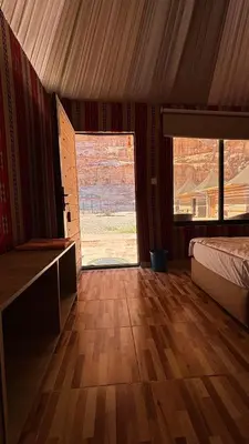 a bedroom with a bed and a large window at altair luxury rum in Wadi Rum