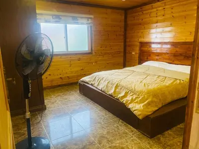 a bedroom with a bed with a fan in it at Green houseجوهره الشمال in Ajloun