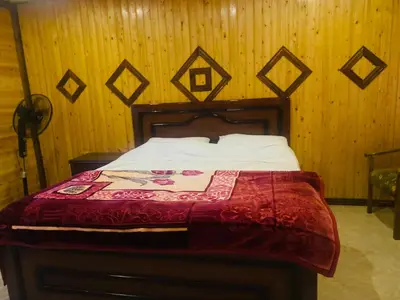 a bed in a room with a wooden wall at Green houseجوهره الشمال in Ajloun
