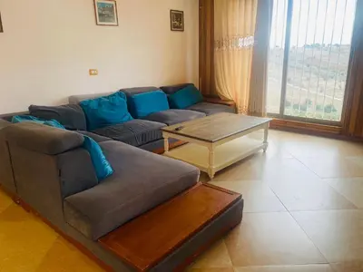 a living room with a couch and a coffee table at Green houseجوهره الشمال in Ajloun