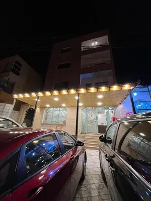 a group of cars parked in front of a building with lights at Nabateans Home Hotel in Wadi Musa