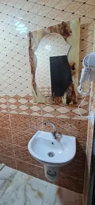 a bathroom with a sink and a picture at Nabateans Home Hotel in Wadi Musa