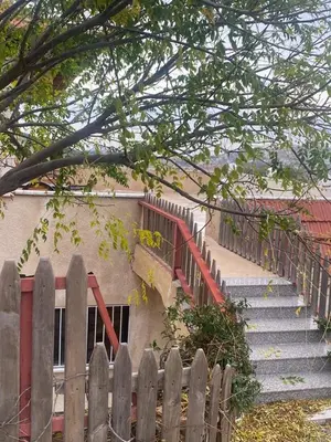 a wooden fence in front of a building with stairs at Green House in Zūbiyā