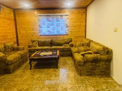 a living room with two couches and a coffee table at Green House in Zūbiyā