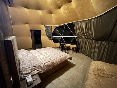a bedroom with a bed and a large window at Wild Oryx Camp Bubbles in Wadi Rum