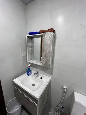 a white bathroom with a sink and a mirror at Wild Oryx Camp Bubbles in Wadi Rum