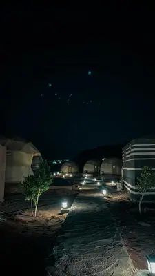 a parking lot at night with lights on it at rum fun luxury camp in Wadi Rum