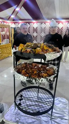 a couple of people standing behind a buffet of food at rum fun luxury camp in Wadi Rum