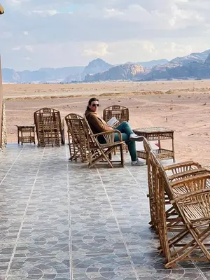 a man sitting in a chair in the desert at Maestro camp Wadi Rum in Wadi Rum