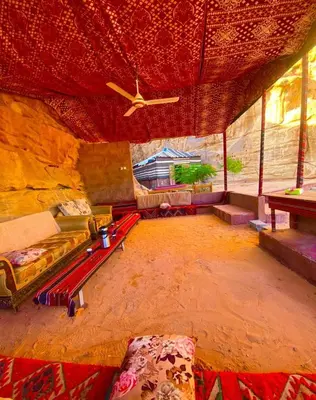 a living room with a couch and a ceiling fan at Serenity Camp in Wadi Rum