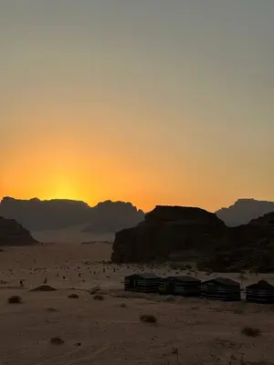 a train in the desert with the sunset in the background at Serenity Camp in Wadi Rum