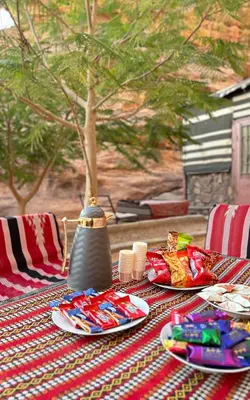 a table with plates of food and a vase on it at Serenity Camp in Wadi Rum