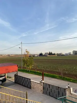 a car parked next to a park with a field at Apartment in madba in Madaba