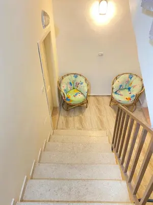 two chairs sitting on the stairs in a room at Apartment in madba in Madaba