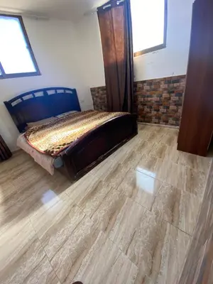 a bedroom with a bed and a wooden floor at Apartment in madba in Madaba