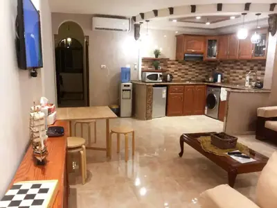 a kitchen and living room with a table and a table at Khirfan Crown Houses -downtown in Amman