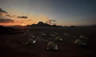 a group of domes on the beach at sunset at Star rum in Wadi Rum