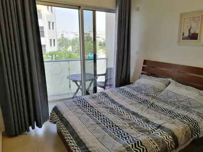 a bedroom with a bed with a view of a balcony at Abdoun studio in Amman