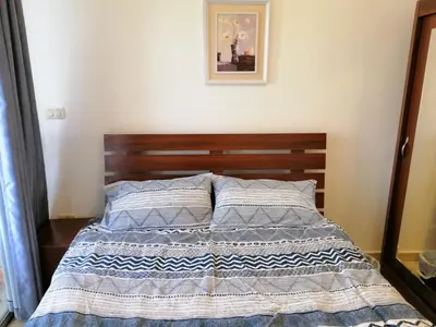 a bed with a wooden headboard in a bedroom at Abdoun studio in Amman