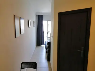 a hallway with a black door and a room at Abdoun studio in Amman