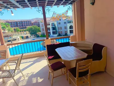a balcony with a table and chairs and a view at Tala bay apartments 2 bedroom for family only in Aqaba
