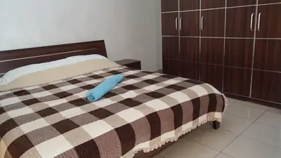 a bedroom with a bed with a blue pillow on it at Nice tow bedrooms by snake pool for families only in Talapay in Aqaba