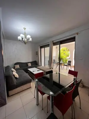 a living room with a couch and a glass table at Nice tow bedrooms by snake pool for families only in Talapay in Aqaba