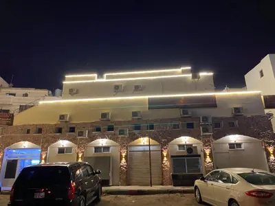 two cars parked in front of a building at night at Golden View in Aqaba