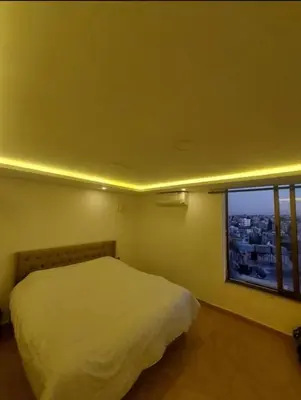 a bedroom with a white bed and a window at The view IV in Amman